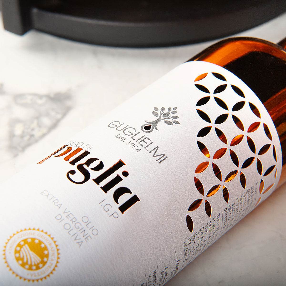 Guglielmi Puglia PGI olive oil bottle with decorative geometric pattern and golden certification seal on white label